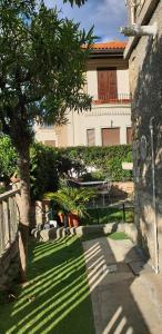 een huis met een boom en een bank in een tuin bij Appartamento Ibisco in Recco