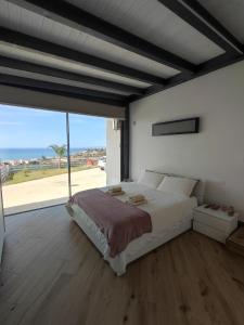 um quarto com uma cama grande e uma janela grande em VILLA Terrazza sul mare em Balestrate
