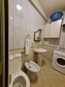 a bathroom with a toilet and a sink and a washing machine at Golem Rajmonda's House in Golem +21 photos