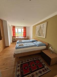 WallseeGasthof Hehenberger的一间卧室配有一张大床和地毯。