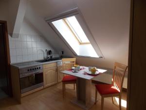 una cucina con tavolo, sedie e finestra di Ferienwohnung Mohnblume - a44686 a Gerswalde
