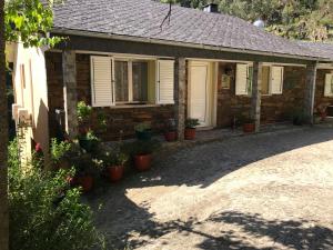 阿鲁卡O refugio do Mineiro的前面有盆栽植物的砖房