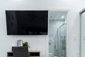 een flatscreen-tv hangend aan een muur in een badkamer bij King Davids Suite Athens finest! in Athene