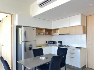 a kitchen with a table and chairs and a refrigerator at New Cozy Apartment with Terrace, Pool and Gym in Guadalajara