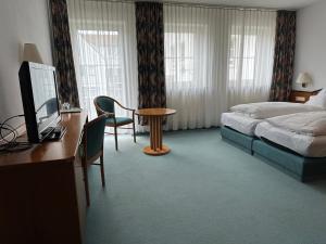 a hotel room with a bed and a desk with a computer at ST Hotel in Reichertshofen