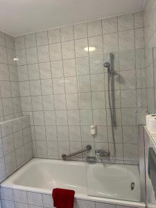 a bath tub with a shower in a bathroom at ST Hotel in Reichertshofen