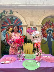 uma mulher em pé em frente a uma mesa com uma mesa roxa em Hotel Boutique Castillo Ines Maria em Cartagena das Índias