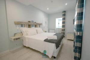 a bedroom with a white bed with a wooden headboard at Casa da Ribeira do Círio in Seia