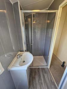 y baño pequeño con lavabo y ducha. en 6 berth Seawick Caravan Park, St Osyth, en Colchester