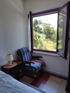 1 dormitorio con silla y ventana grande en Borgo Ingurtosu, en Ingurtosu
