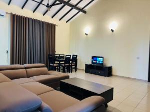 a living room with couches and a table and a tv at Viveka Serviced Apartments in Nugegoda