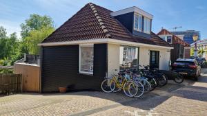 un grupo de bicicletas estacionadas fuera de una casa en Het Huis Met De Groene Deur, en Ámsterdam