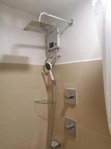 a shower with a shower head in a bathroom at Moa shore 3 residence in Manila