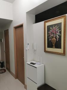 una habitación con una foto de un jarrón en la pared en Moa shore 3 residence en Manila