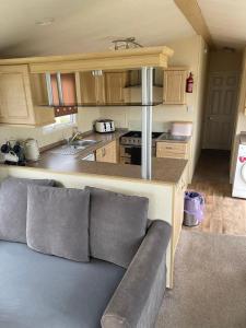 a living room with a couch in a kitchen at 6 berth Seawick Caravan Park, St Osyth in Colchester