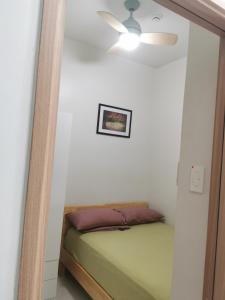 マニラにあるMoa shore 3 residenceのベッドルーム1室(ベッド1台、シーリングファン付)