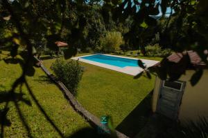 a swimming pool in a yard next to a house at Casa da Ribeira do Círio in Seia