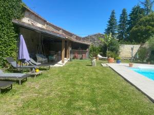 une maison avec une cour et une piscine dans l'établissement Gîte l’aroma, 