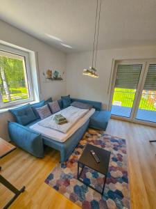 a bedroom with a bed and a blue couch at EcoCube 442 - Balkon, 2Zimmer, Waschmaschine, Schlafsofa in Meppen