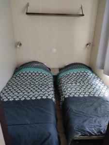 um pequeno quarto com duas camas em Camping du phare d opale p48 em Le Portel