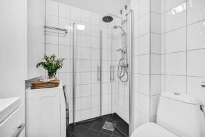 uma casa de banho branca com um chuveiro e um WC. em Beautiful apartment at Frogner Oslo em Oslo