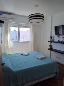 une chambre avec un lit avec deux serviettes dessus dans l'établissement Cómodo apartamento frente Quinta Presidencial, à Florida