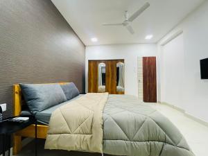 STAYLUXE-MUMBAI AIRPORT في مومباي: غرفة نوم بسرير واريكة