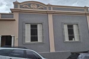 um edifício com duas janelas e um carro estacionado em frente em Casa de Temporada Uberaba 2 em Uberaba