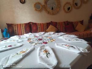 una mesa con mantas blancas y flores. en DAR SARSAR airport, en Marrakech