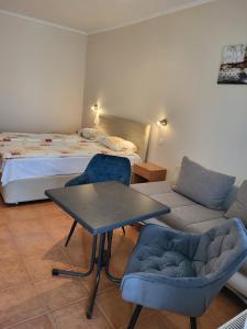 a bedroom with a bed and a table and chairs at Tip-Top Apartmenthouse in Balatonfüred