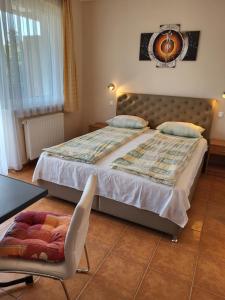 a bedroom with a large bed and a chair at Tip-Top Apartmenthouse in Balatonfüred