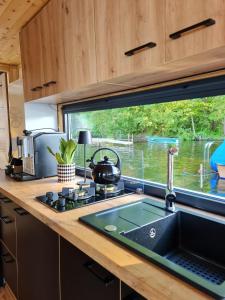 eine Küchentheke mit einem Waschbecken und einem Fenster in der Unterkunft Seezeit im Hausboot mit Kamin & Sauna in Müllrose