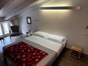 a bedroom with a bed with a red blanket on it at Maison Tatà in Aosta