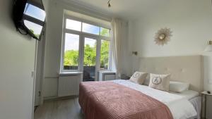 a bedroom with a large bed and a window at Heritage House in Klaipėda