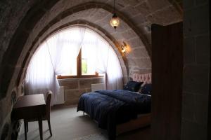 1 dormitorio con 1 cama en una pared de piedra en Burhan bey konagı, en Askaray