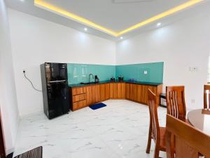 a kitchen with a black refrigerator and wooden cabinets at NHỚ House Đà Lạt V in Da Lat