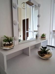 ein Bad mit einem Waschtisch mit einem Spiegel und Pflanzen darauf in der Unterkunft Il Rifugio di Garibaldi in Neapel