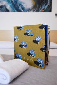 un libro con ombrelloni su un letto di Hotel Umberto a Lido di Jesolo