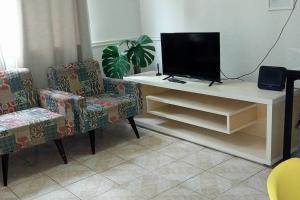 Apto Inteiro Stiep في سلفادور: غرفة معيشة مع تلفزيون وكرسيين