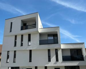 ピテシュティにあるCASA VYSの青空に向かって黒窓のある白い建物