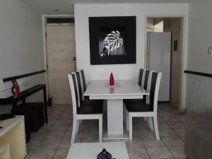 Apto Inteiro Stiep في سلفادور: طاولة بيضاء مع كراسي وصورة هيكل عظمي