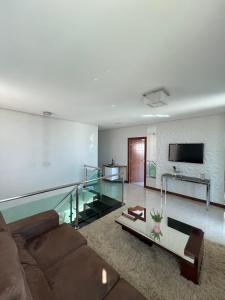 uma sala de estar com um sofá e um piso de vidro em Casa com 4 suítes, todas as suítes com ar condicio em Vitória da Conquista