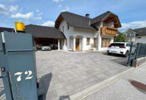 a house with a car parked in a driveway at SOS Apartments in Radovljica