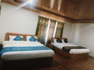 2 letti in una camera con di The Other House Srinagar a Srinagar