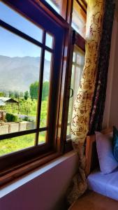 una finestra con vista sulle montagne di The Other House Srinagar a Srinagar