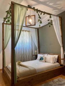 a bedroom with a canopy bed with leaves on the ceiling at Alojamento D Duarte in Gouveia