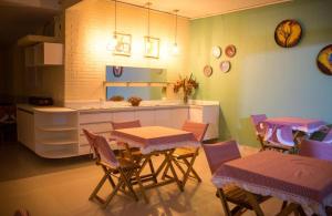 a dining room with a table and chairs and a kitchen at A Cabana pousada in Maceió