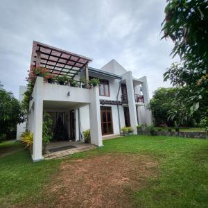 a white house with a lawn in front of it at Quin Villa in Katukurunda-Kalutara