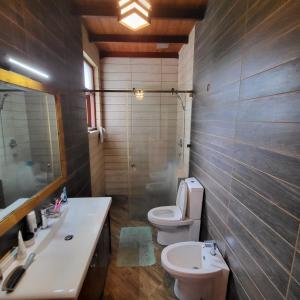 ein Badezimmer mit einem WC, einem Waschbecken und einem Spiegel in der Unterkunft Quin Villa in Katukurunda-Kalutara