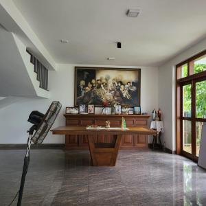 una habitación con una mesa y una pintura en la pared en Quin Villa en Katukurunda-Kalutara